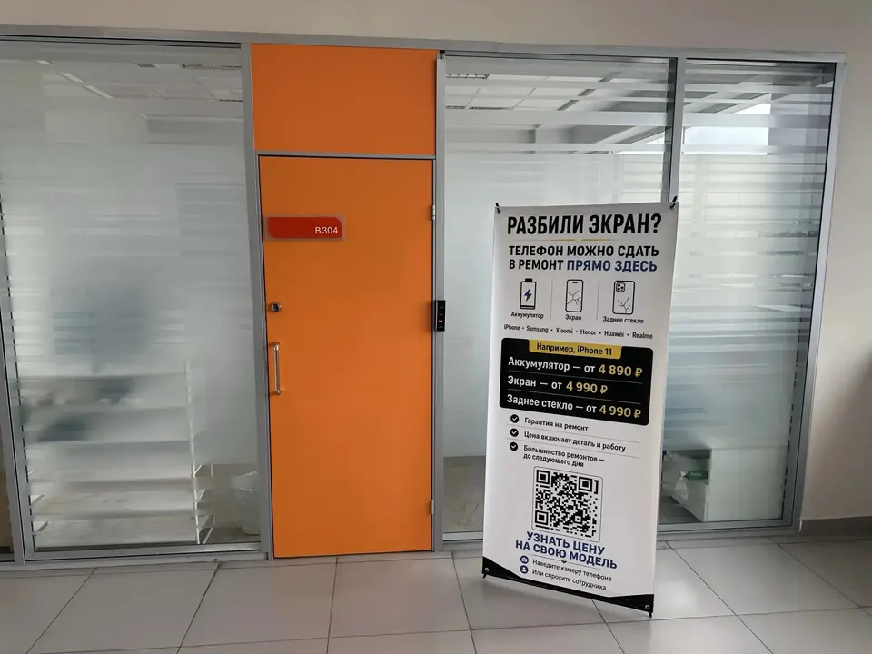Оранжевая дверь офиса B304 и баннер пункта приёма смартфонов в IT-парке